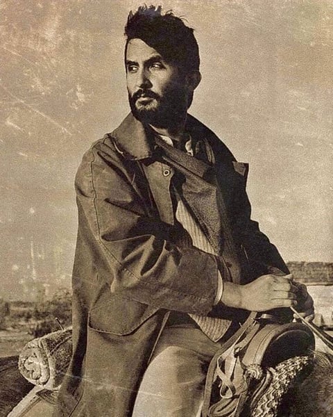 Vintage portrait of a bearded man in casual clothing seated outdoors